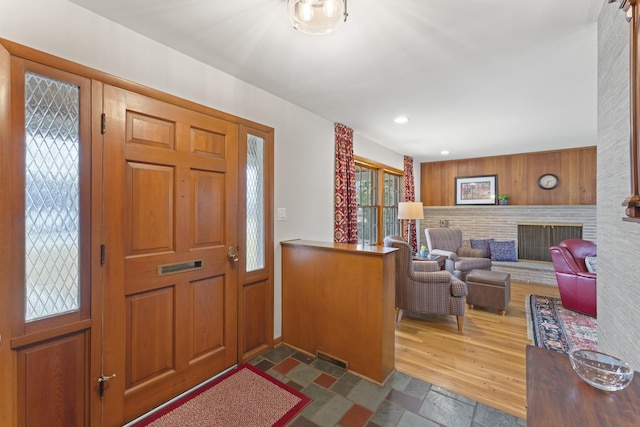 entrance foyer with a fireplace, stone tile flooring, and recessed lighting