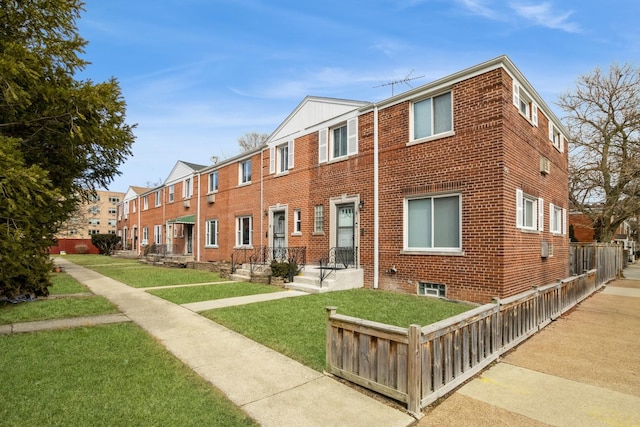 view of front of property with a front yard and brick siding