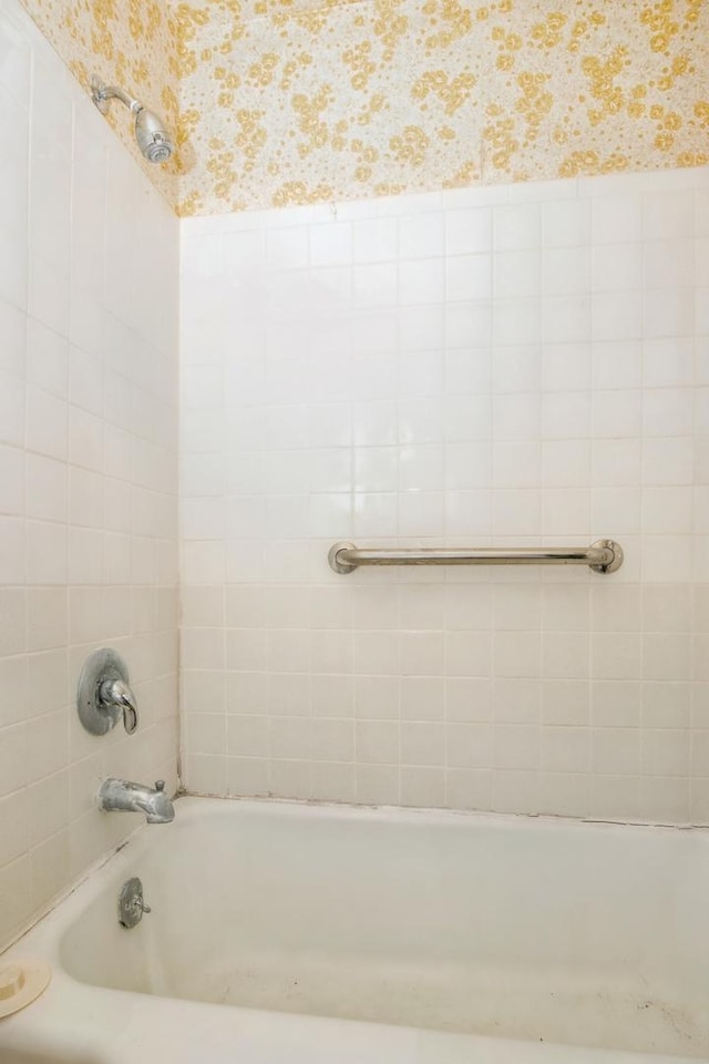 full bathroom with wallpapered walls and bathtub / shower combination