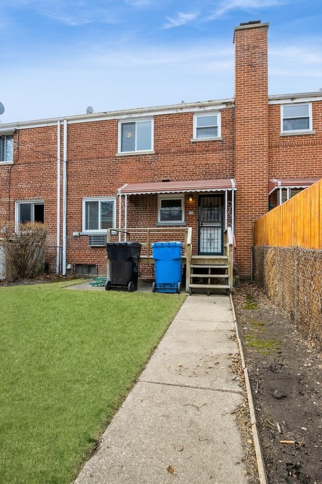 view of front of property with fence, a front lawn, and brick siding