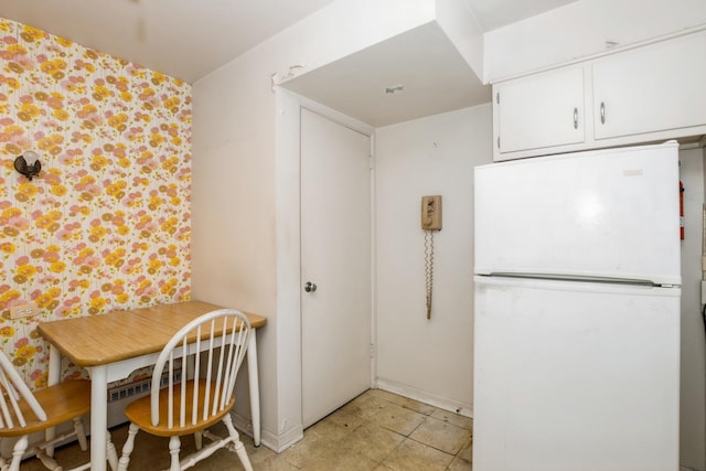 kitchen with white cabinets and freestanding refrigerator