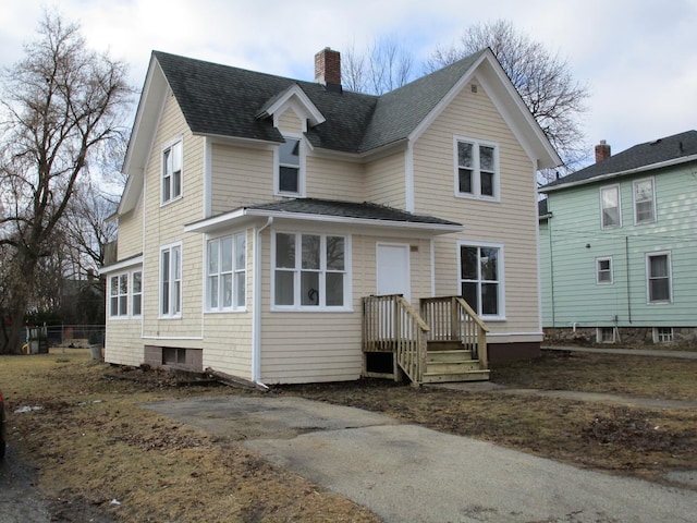 view of front of home with roof with shingles and a chimney