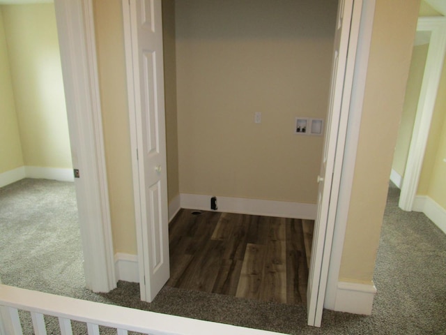 washroom featuring hookup for a washing machine, baseboards, wood finished floors, and carpet flooring