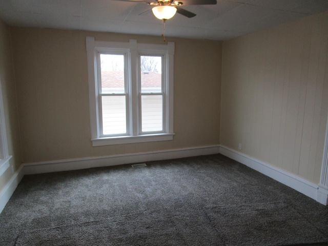 spare room featuring carpet floors, a wealth of natural light, visible vents, and baseboards