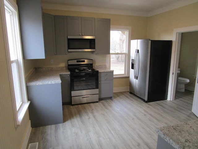 kitchen with ornamental molding, visible vents, stainless steel appliances, and gray cabinetry