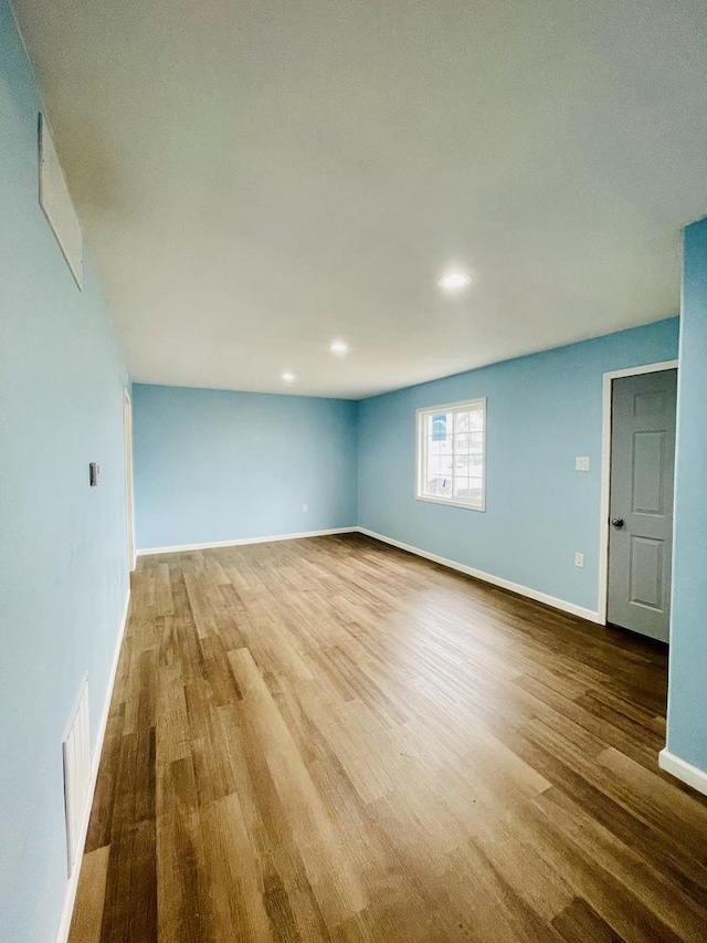 empty room featuring recessed lighting, visible vents, baseboards, and wood finished floors