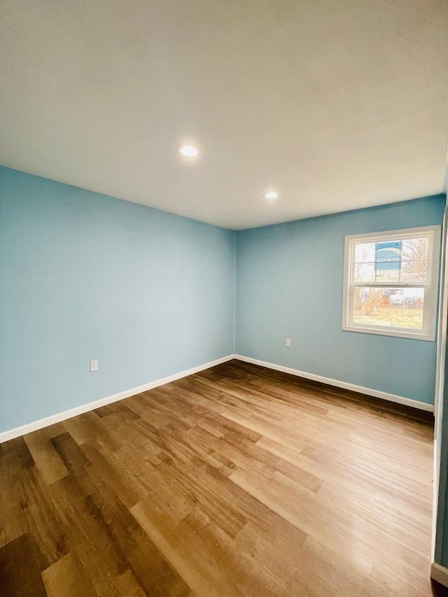 empty room featuring recessed lighting, baseboards, and wood finished floors