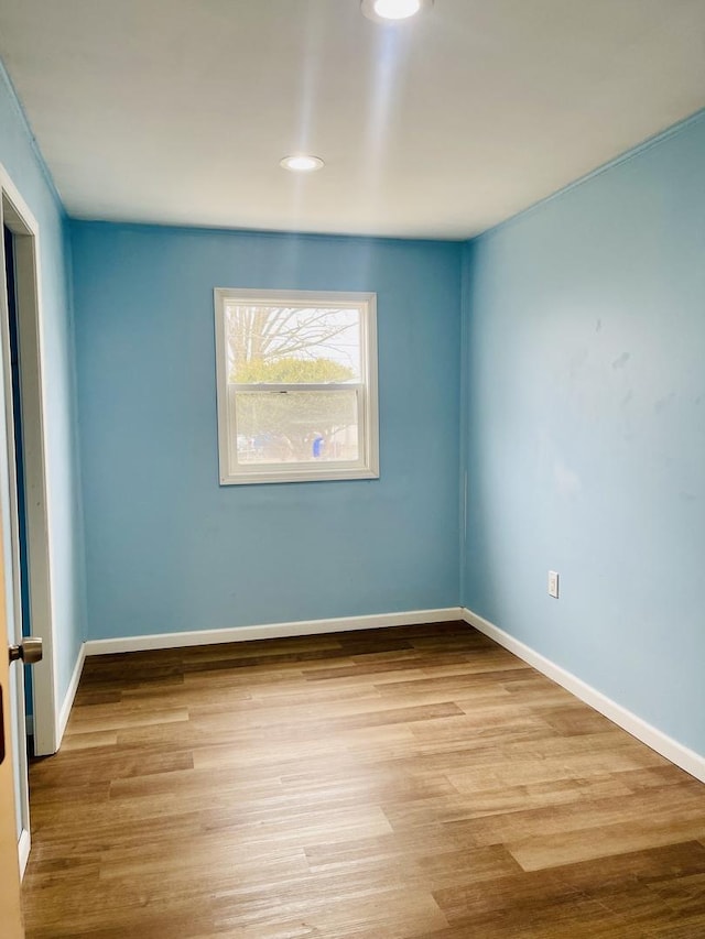 unfurnished room featuring baseboards and wood finished floors