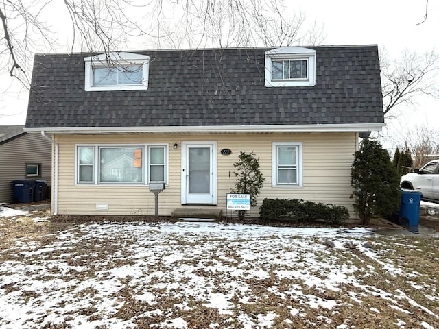 view of front facade with entry steps, mansard roof, and roof with shingles