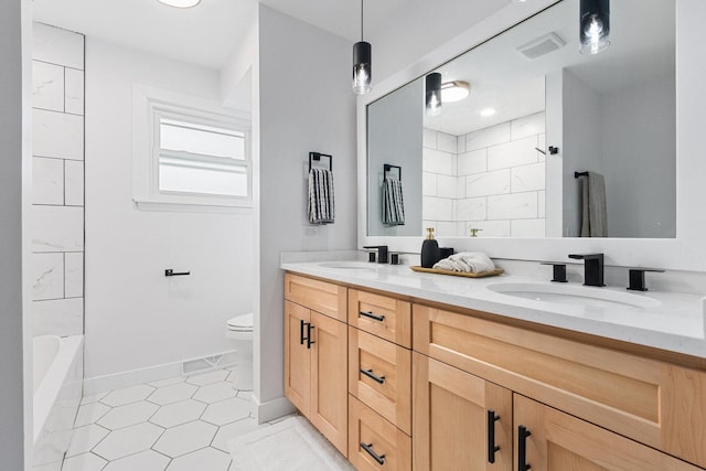 full bathroom with toilet, double vanity, a sink, and visible vents