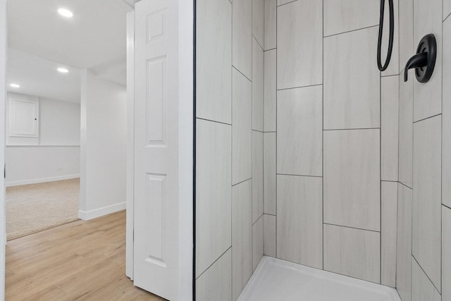 interior space featuring tiled shower, recessed lighting, wood finished floors, electric panel, and baseboards