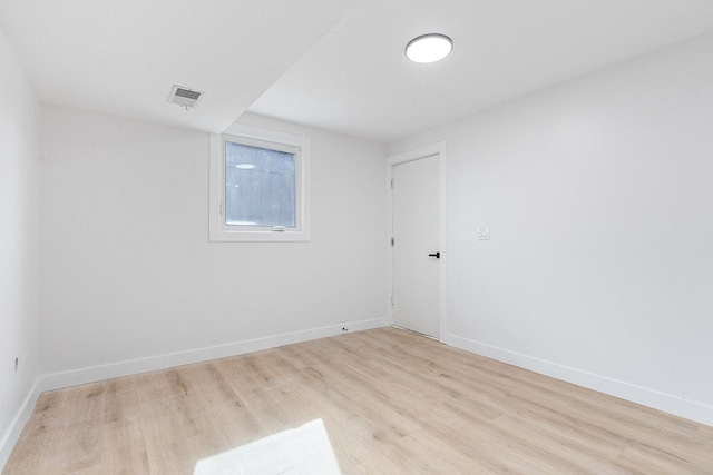 spare room featuring baseboards, visible vents, and light wood finished floors