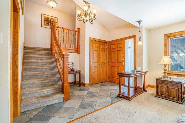 carpeted foyer with stairway, baseboards, an inviting chandelier, and vaulted ceiling