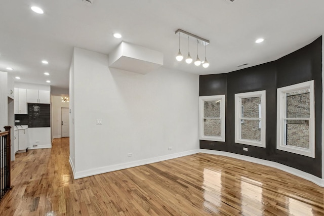 unfurnished room with recessed lighting, light wood-type flooring, visible vents, and baseboards