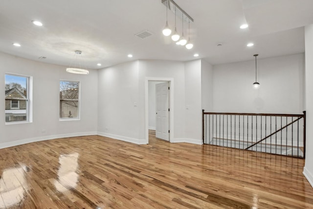 spare room featuring recessed lighting, visible vents, baseboards, and wood finished floors