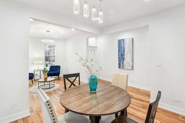 dining area featuring baseboards and light wood-style floors