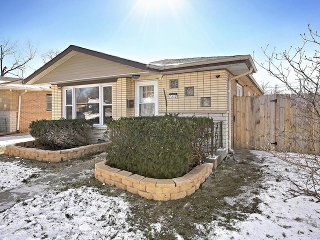 ranch-style house with fence and brick siding