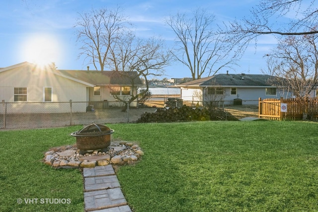 view of yard featuring an outdoor fire pit and fence