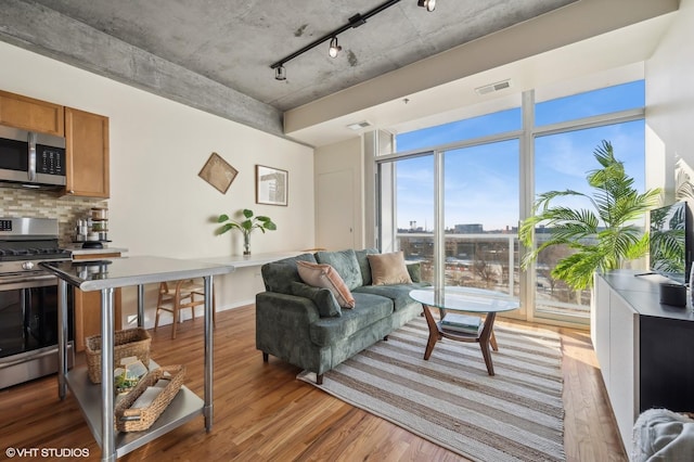 living room featuring light wood-type flooring, baseboards, and visible vents