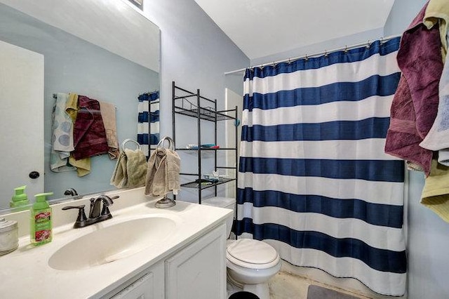 bathroom with curtained shower, vanity, and toilet