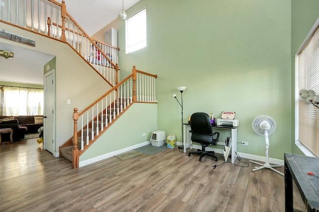 office area with a high ceiling, wood finished floors, and baseboards