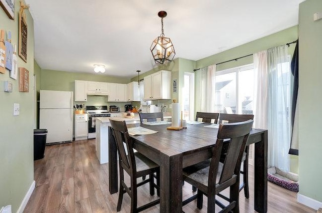 dining room with an inviting chandelier, wood finished floors, and baseboards