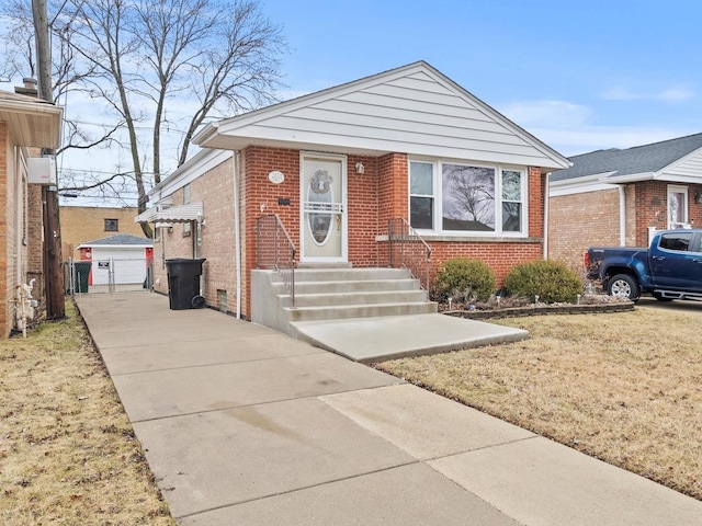 bungalow featuring brick siding and driveway