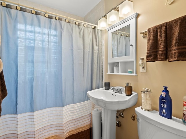 full bath featuring a shower with curtain and toilet