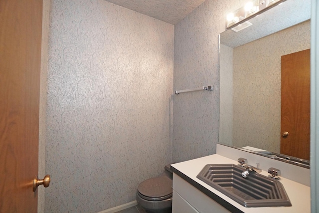 bathroom featuring visible vents, vanity, and toilet