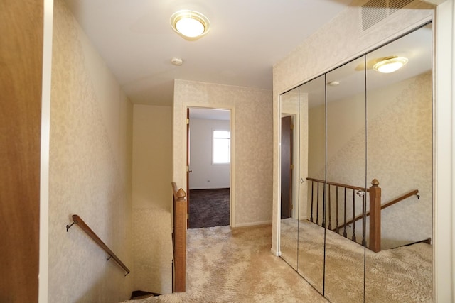 hallway featuring carpet and an upstairs landing