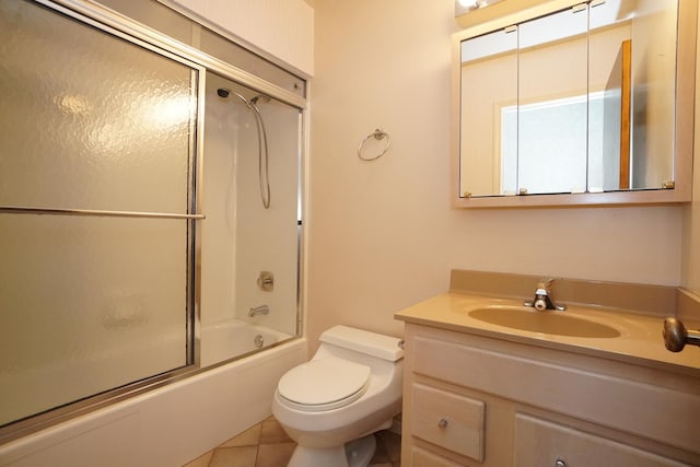 full bathroom featuring toilet, tile patterned flooring, bath / shower combo with glass door, and vanity