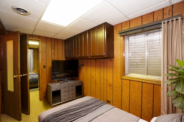 bedroom featuring wooden walls, visible vents, and a drop ceiling