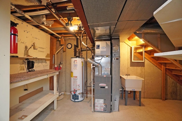 utility room featuring water heater and a sink