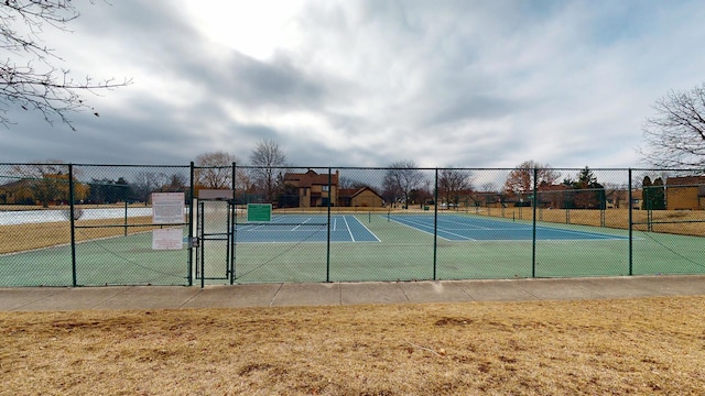 view of tennis court featuring a gate and fence