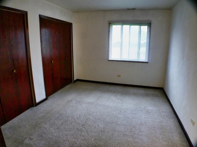 15805 Peggy Ln Unit 2, Oak Forest, IL 60452 - unfurnished bedroom with multiple closets, light carpet, visible vents, and baseboards