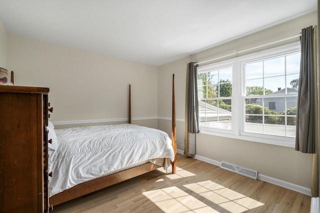 bedroom featuring baseboards, visible vents, and light wood-style floors