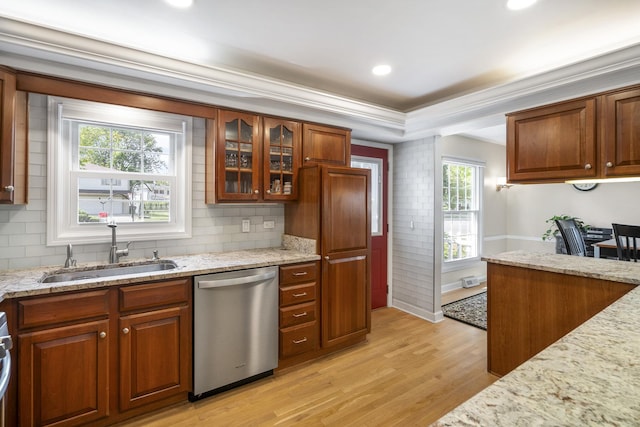 kitchen featuring light stone counters, glass insert cabinets, a sink, light wood-type flooring, and dishwasher