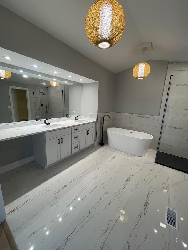 bathroom featuring lofted ceiling, a freestanding tub, a sink, and double vanity