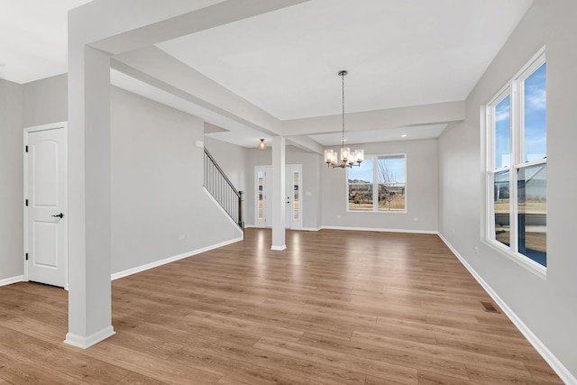 733 Juniper St, Oswego, IL 60543 - unfurnished dining area featuring stairs, light wood-style floors, and a chandelier