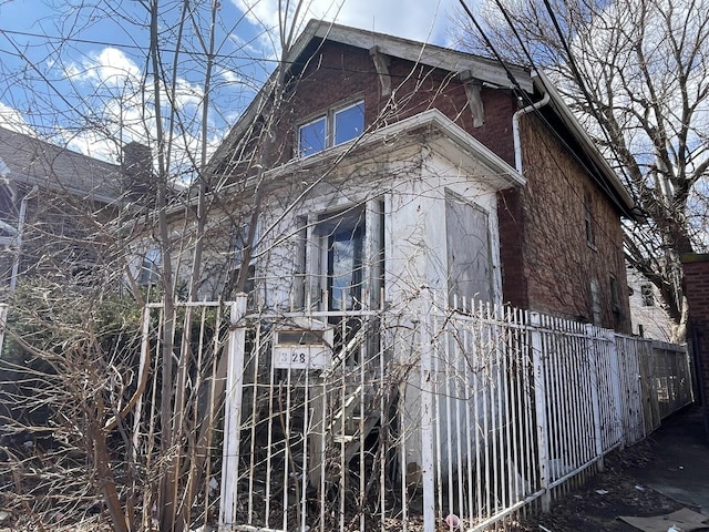 view of home's exterior featuring brick siding and fence