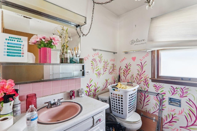 half bath with toilet, backsplash, and vanity