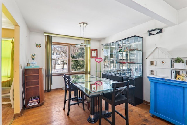 dining space featuring baseboards and hardwood / wood-style floors