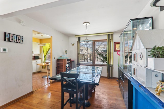 dining room featuring baseboards and hardwood / wood-style flooring