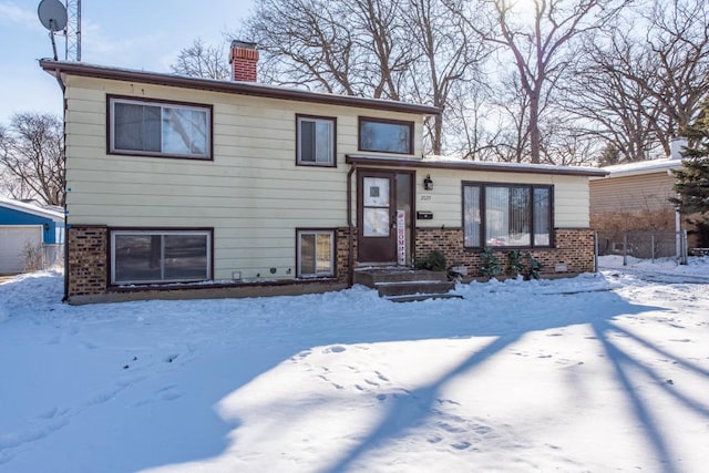 split level home with brick siding and a chimney