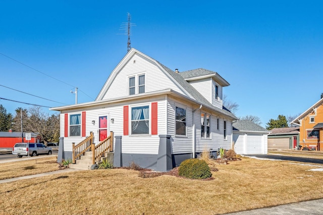 colonial inspired home with a garage, a shingled roof, and a front lawn