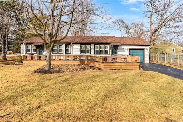 ranch-style home featuring driveway, a garage, a chimney, fence, and a front lawn