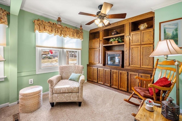 sitting room featuring baseboards, visible vents, a ceiling fan, light colored carpet, and ornamental molding