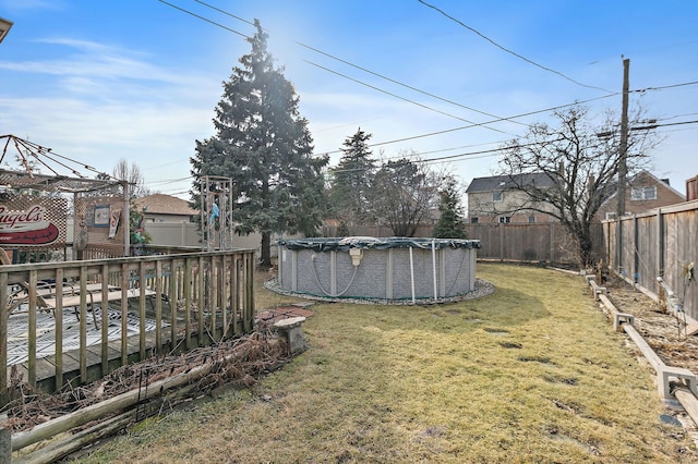 view of yard featuring a wooden deck, a fenced backyard, and a fenced in pool