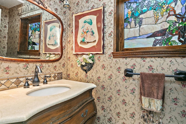 bathroom featuring vanity and wallpapered walls