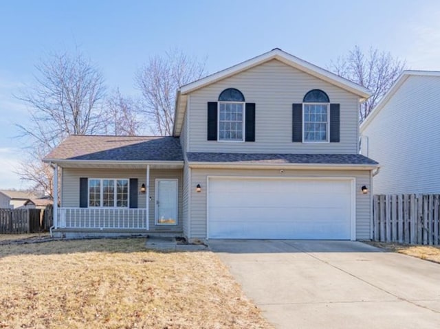 traditional home with a porch, concrete driveway, fence, a garage, and a front lawn